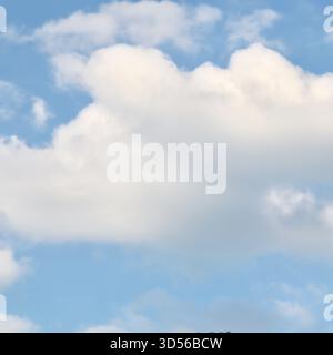 A serene sky background featuring a large, fluffy cumulus cloud that dominates the bottom frame, set against a soft and clear pale blue sky above, per Stock Photo
