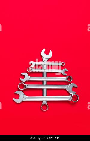 Christmas tree made of wrenches on a red background. Tool set. Happy new year with industrial holiday concept. Close-up Stock Photo