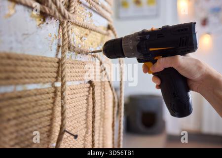 A skilled handyman is using a powered drill on a textured wall to enhance home improvement Stock Photo