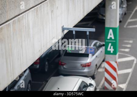 A modern car park with a digital LED sign, highlighting urban infrastructure and parking guidance technology. The multi-story concrete structure and c Stock Photo