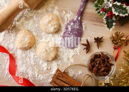 Wooden kitchen bench preparing anise cookies with scattered flour, tools and ingredients around. Top view. Stock Photo