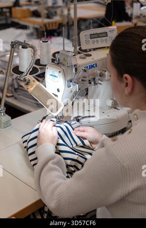 Saint-James (Normandy, north-western France): at the heart of the “Saint James” factory. Woman, worker operating a Juki sewing machine Stock Photo