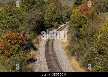 Empty train track going through fall foliage Stock Photo