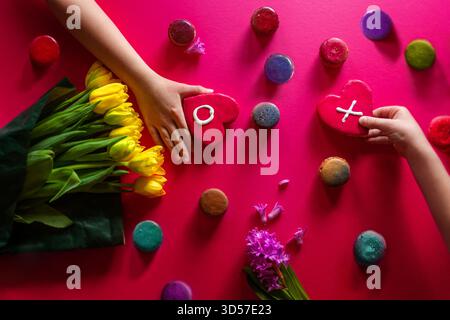 Hands holding Valentine Cookies with flowers and Pink background Stock Photo
