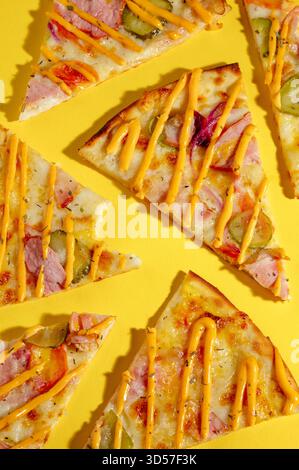 slices of pizza on a yellow background with ham Stock Photo