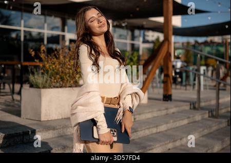 Young Woman Enjoying Sunlight with Laptop Outdoors Stock Photo