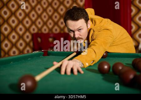 Man plays billiards in a vintage themed bar during the evening Stock Photo