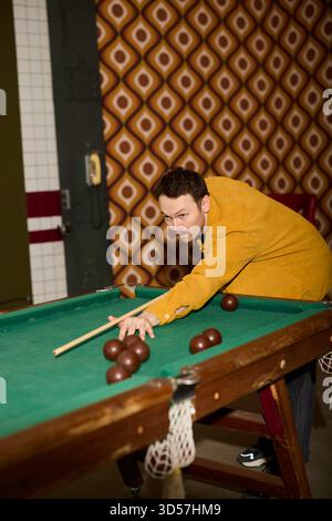 Man playing billiards in vintage setting with retro decor Stock Photo