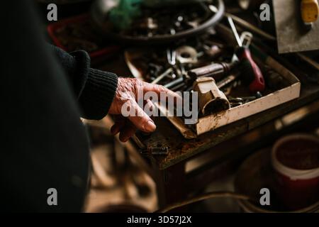 Finding tools in a cluttered workspace filled with various hand tools Stock Photo