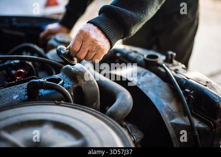 Man inspecting car engine in workshop Stock Photo
