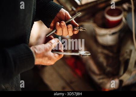Skilled mechanic working with tools in an auto workshop Stock Photo