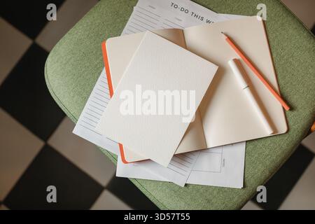 Close-up overhead view of a to do list on a chair with an open notebook, pen and pencil Stock Photo