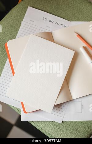 Close-up overhead view of a to do list on a chair with an open notebook, pen and pencil Stock Photo
