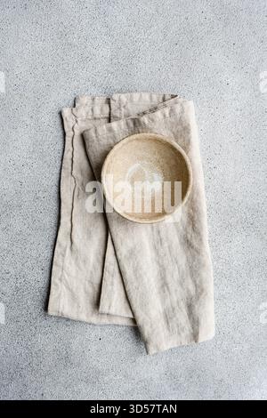 Overhead view of a ceramic bowl on a folded napkin on a table Stock Photo