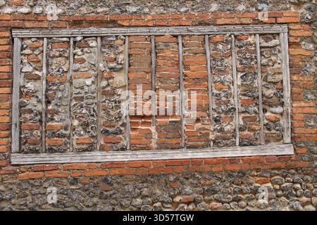 A Mixed Building Wall of Bricks and Flint Stones. Stock Photo