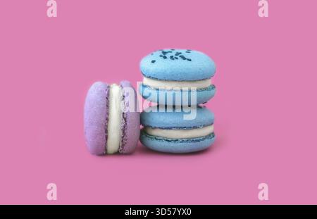 Blue and purple macaroons on a bright pink background. A French dessert. Multicolored macaroons multicolored macarons on a pink background Stock Photo