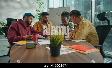 Informal business team four co-workers diversity people corporate group of multiracial workers discussing project strategy in coworking office Stock Photo