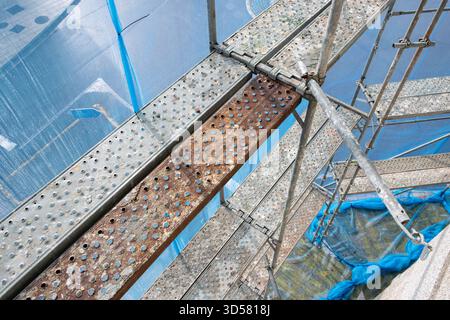 Scaffolding structure providing temporary access with platforms and protective netting Stock Photo