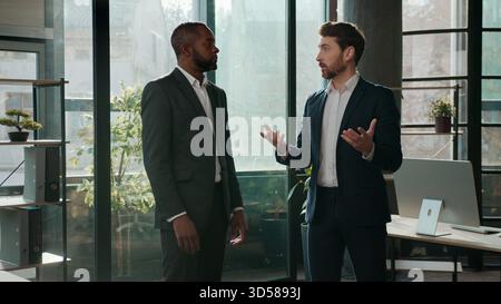 Diverse ethnic business men team businessmen talking formal communication in office male employers discussing project multiracial managers Stock Photo