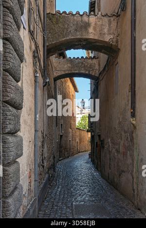 Italy - Orvieto - Orvieto Old Town - Empty narrow cobblestone street with stone arches overhead Stock Photo