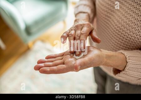 Senior woman applying moisturizer to her hands, close-up Stock Photo