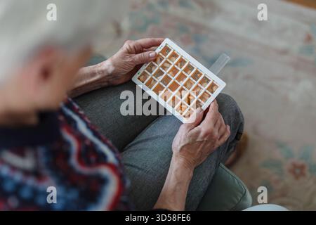 Senior woman taking her medication at home, close-up of hands Stock Photo