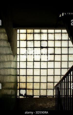 Green old glass brick window in a dilapidated building Stock Photo