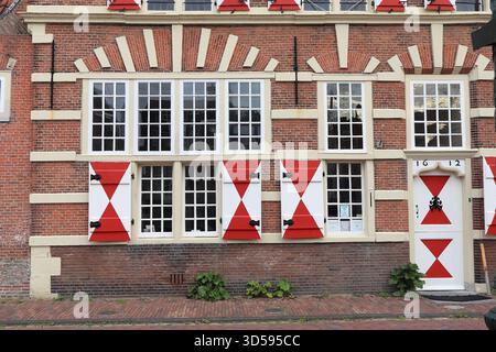 Old Brick Building Facade Detail with White and Red Shutters in Leiden, Kort Galgewater, Netherlands, November 2025 Stock Photo