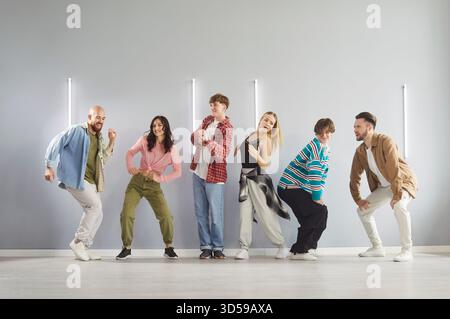 Group of diverse energetic dancers posing in dance studio and practicing hip hop choreography. Stock Photo