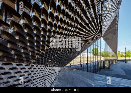 Close-up view of a striking modern architectural facade in Katowice, Poland. The building features a dynamic pattern of metallic panels and reflective Stock Photo