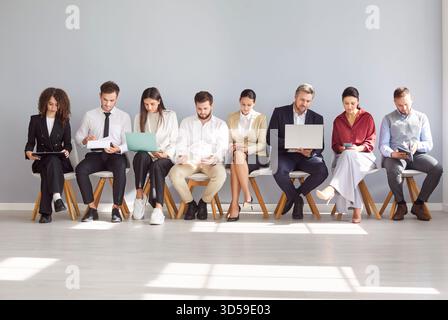 Diverse job candidates, people sitting in office hall on chairs in row, businesspeople waiting Stock Photo