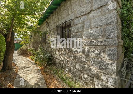 A perimeter path is paved with granite slabs of varying sizes and adorned with centuries-old olive trees planted alongside the stone wall, creating fo Stock Photo