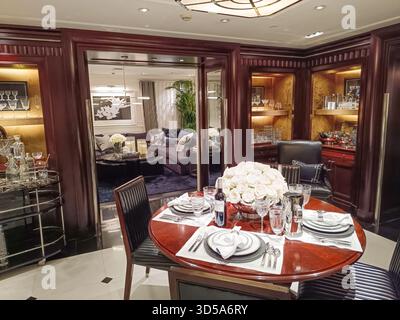 Luxury yacht dining room with polished wood and crystal tableware. London, UK, 8 June 2024 Stock Photo