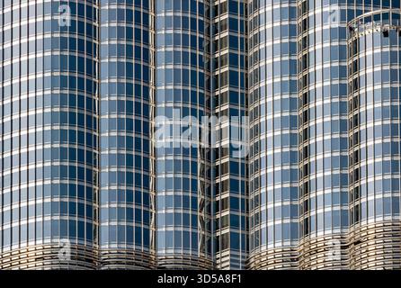 A close-up view of sleek glass building featuring curved, reflective facades and grid-like windows. Stock Photo