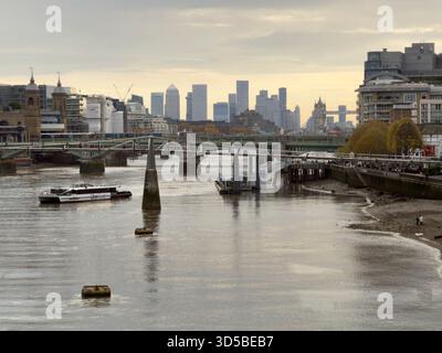 Uber Boat on the River Thames, London, with Canary Wharf skyline and Tower Bridge in the distance. Stock Photo