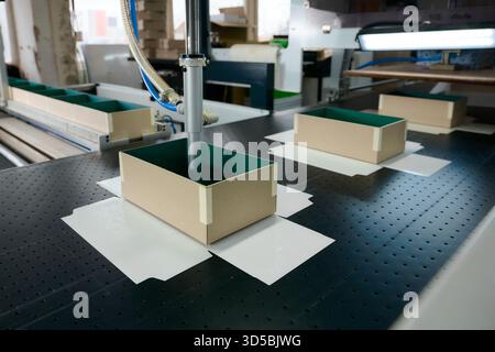 Innovative robotic technology enhances gluing process in cardboard box manufacturing at a modern production plant Stock Photo