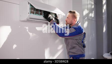 Professional AC Technician Checking Air Conditioner Filter In Home Stock Photo