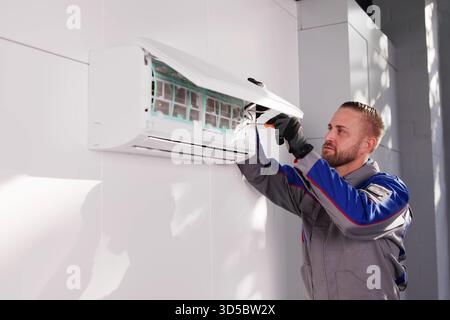 Skilled AC Technician Performs Installation, Repair, And Maintenance Of Conditioner. Stock Photo
