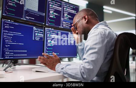 Sad Programmer Frustrated By Coding At Business Desk With Broken System. Stock Photo