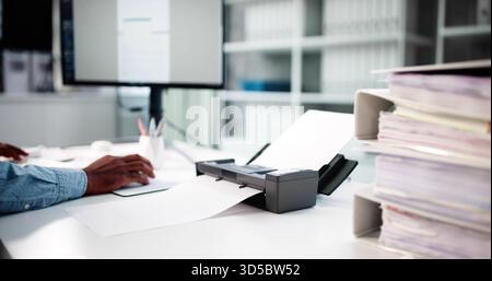 African American Man In Modern Office Using OCR For Invoice. Stock Photo