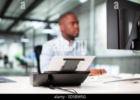 Man Digitizing Paper Documents Using Scanner In Office Profession: Accountant Stock Photo