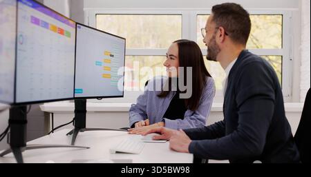 Man And Woman Brainstorm Business Ideas Using Computer For Analytics. Stock Photo