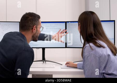 Agile Pair Programming And Extreme Coding: Two Developers Collaborating At Desks. Stock Photo