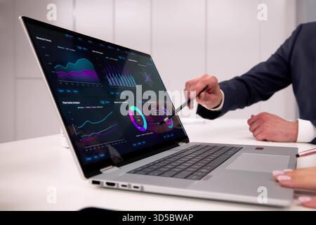 Financial Analysts Utilizing Dashboard Software On Laptop To Predict Market Stock Photo