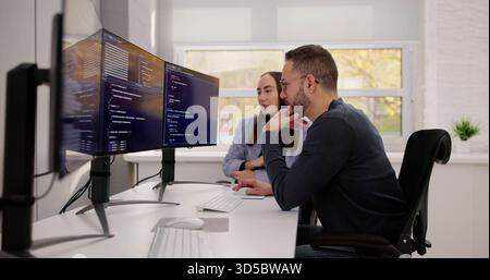 Two Young Caucasians Collaborating On PC Engineering Code Development Project Stock Photo