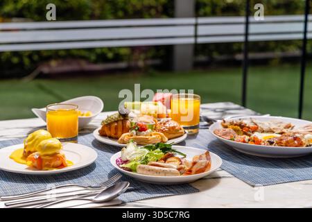 Delicious brunch spread on outdoor patio with fresh juice, eggs Stock Photo