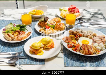 Vibrant breakfast spread on marble table includes eggs Benedict, Stock Photo