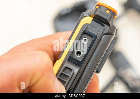 Yellow handheld walkie-talkie with PTT microphone connection detail. Stock Photo