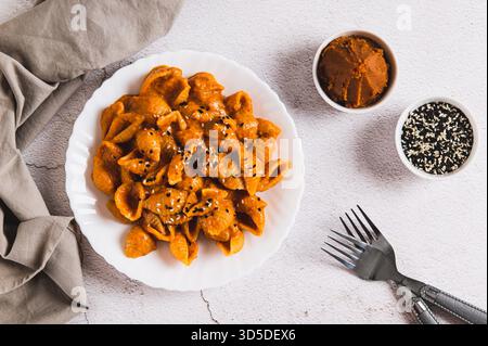 Spicy miso pasta shells on a plate on the table top view Stock Photo