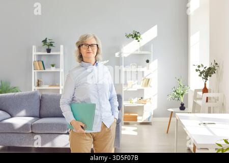 Portrait of confident smiling senior woman standing at home and looking cheerful at camera Stock Photo